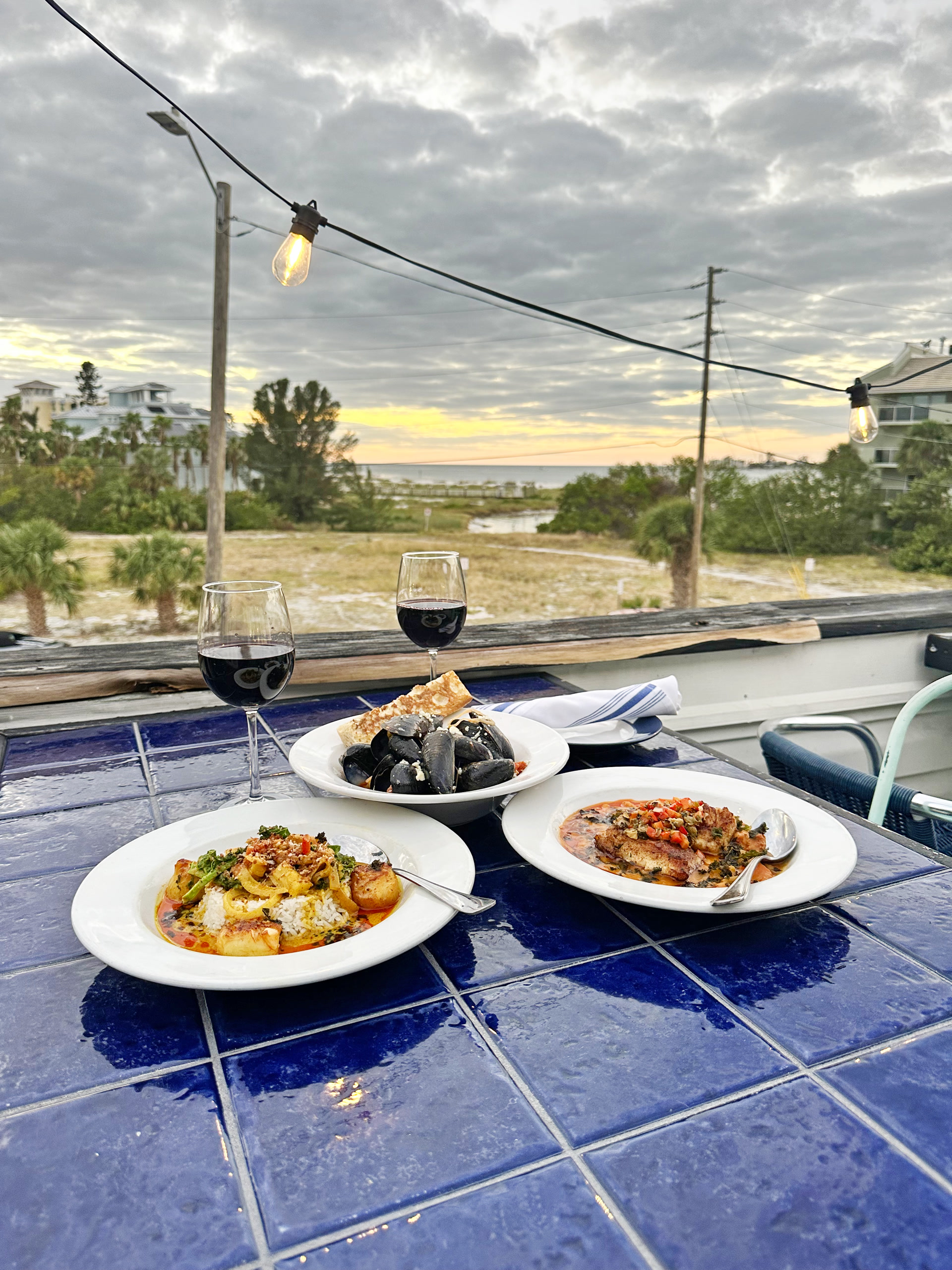 Dishes and wine at Seaworthy Fish and Bar with sunset views over Tierra Verde